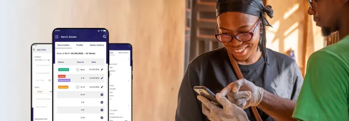 A man is showing a woman how to track her vaccinations by digital innovation in CIMA care system