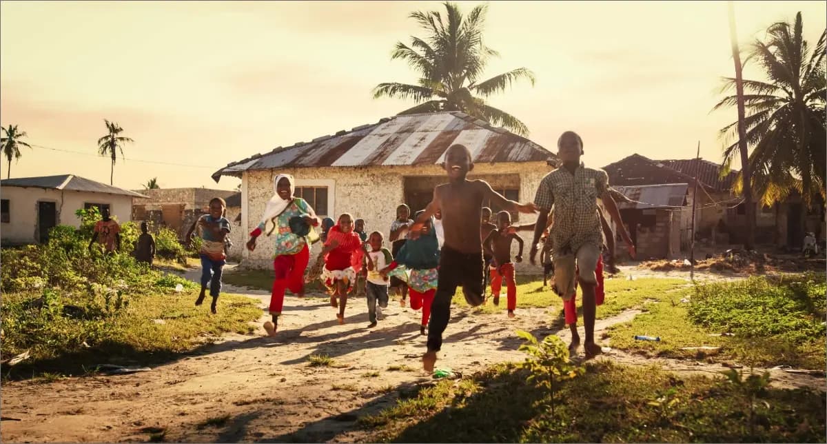 Children running in a rural area, highlighting vaccine impact on health equity and AMR reduction.