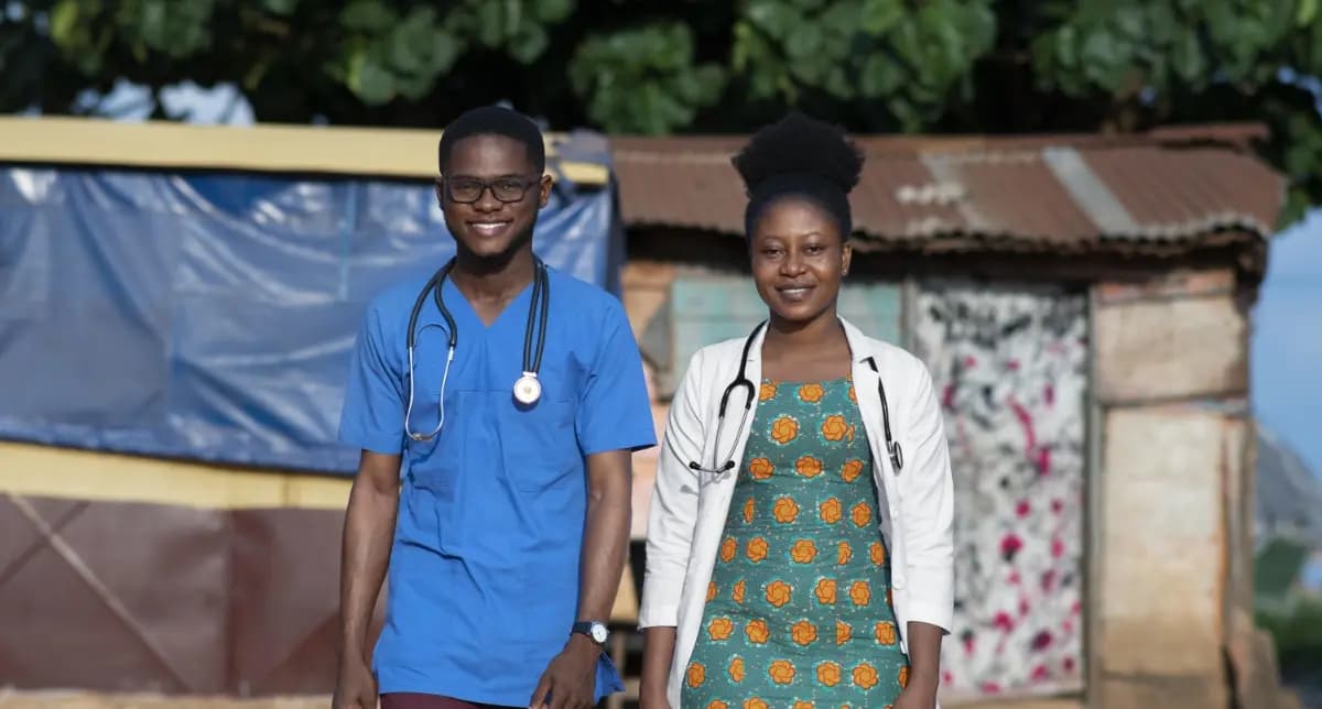 African community health workers in medical dress smiling together in local healthcare settings.