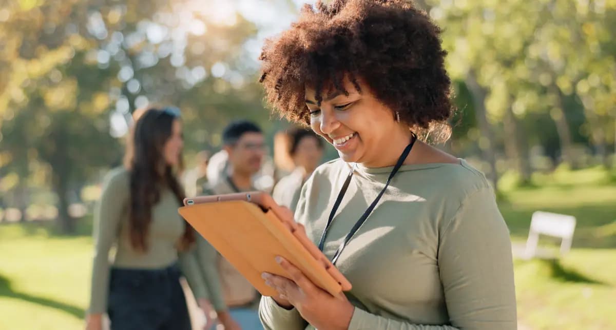 CHW recording vaccination data on tablet while interacting with community members.